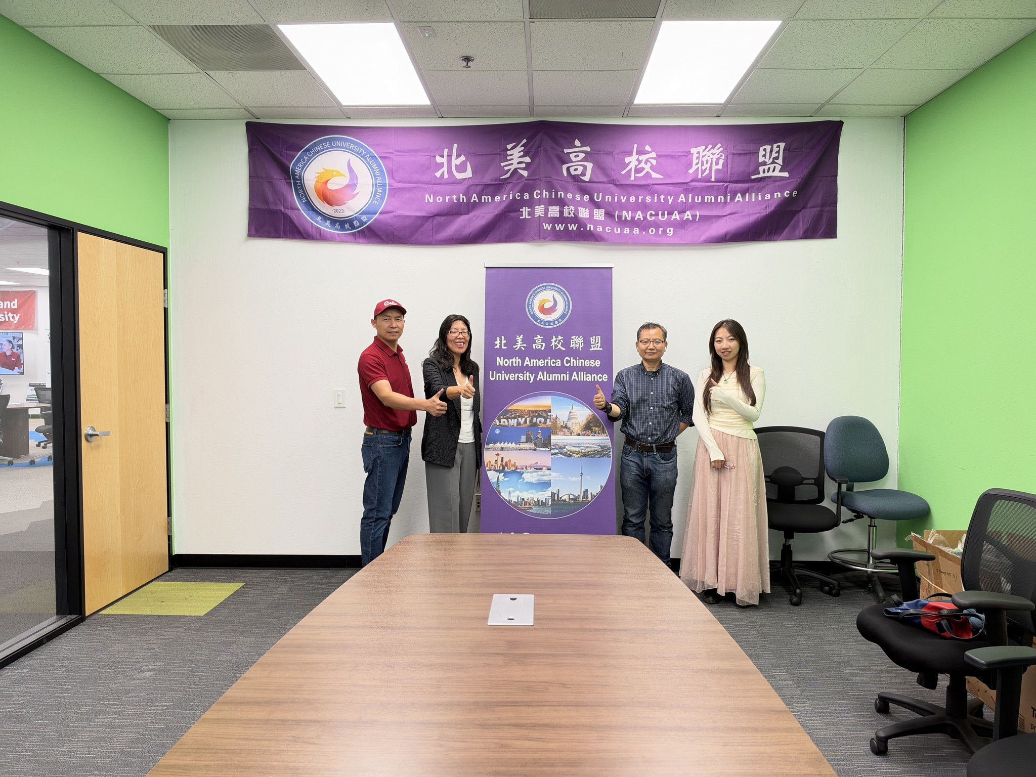 Figure: Attendees posing in front of the NACUAA banner